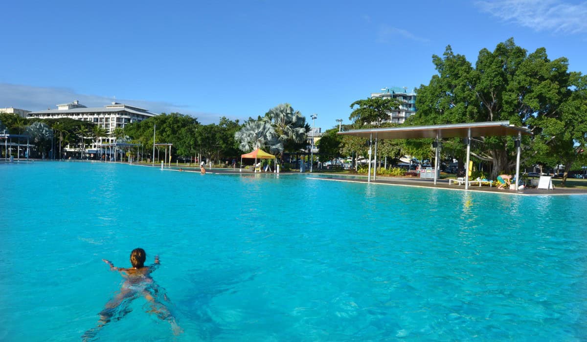 Cairns Esplanade Lagoon with palm trees and city buildings